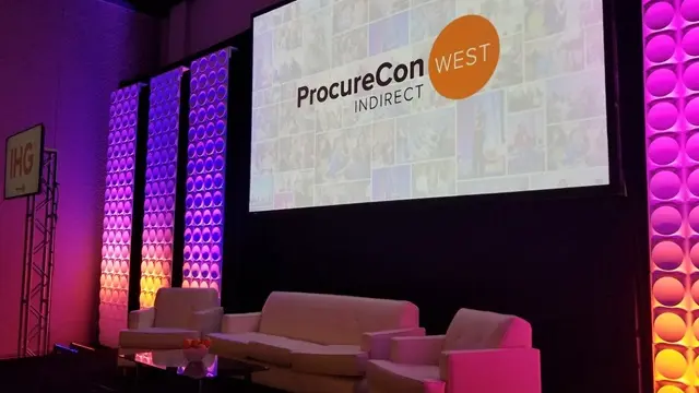 Close-up of the ProcureCon West plenary stage featuring modular scenic production, 5600K calibrated lighting, and a high-contrast 8K display screen for executive presentations.