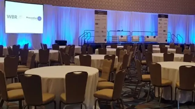 A high-occupancy plenary hall for ProcureCon West featuring enterprise event set design, theater-style sightline planning, and synchronized multi-screen brand immersion.