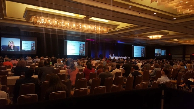 AV production team managing a virtual corporate event in San Diego with professional stage lighting, large projection screens, and a live audience.